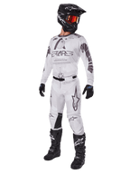 Alpinestars 2025 Racer Hollow Pants, Motocross Pants, Light Camo Brown, shown as part of a complete racing kit with a white jersey, black helmet, and black boots, featuring reinforced black knee panels and a subtle camouflage design.