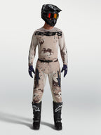 Alpinestars Racer Lone utrustningsset, beige ökenkamouflage, motocrosströja och byxor på modell med svart hjälm och stövlar.