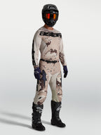 Alpinestars Racer Lone Gear Set, komplett motocrossutrustning i tan och brun camo, tröja och byxor med svarta motorcykelstövlar och hjälm, optimerad för terrängkörning