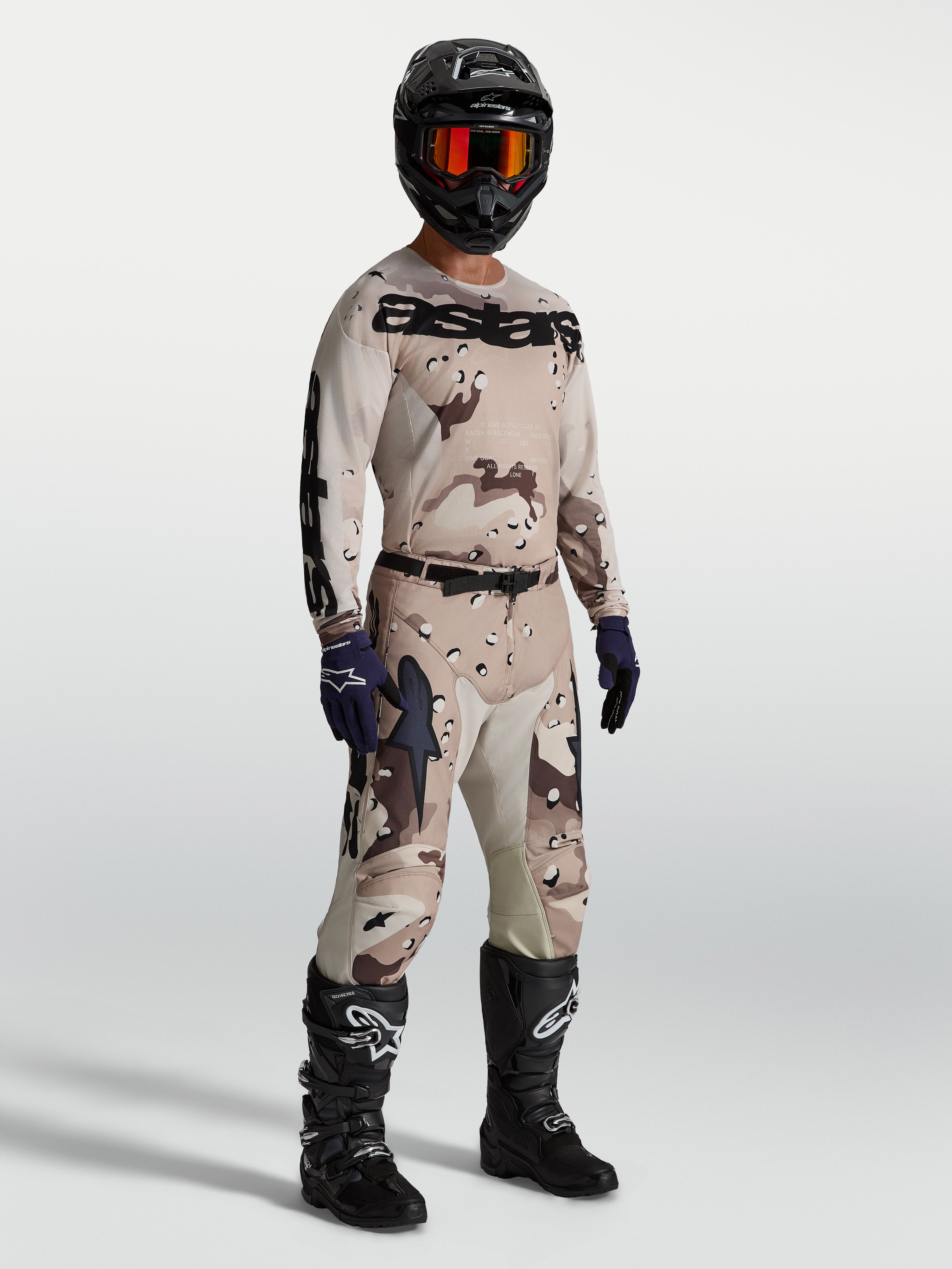 Alpinestars Racer Lone Gear Set, komplett motocrossutrustning i tan och brun camo, tröja och byxor med svarta motorcykelstövlar och hjälm, optimerad för terrängkörning