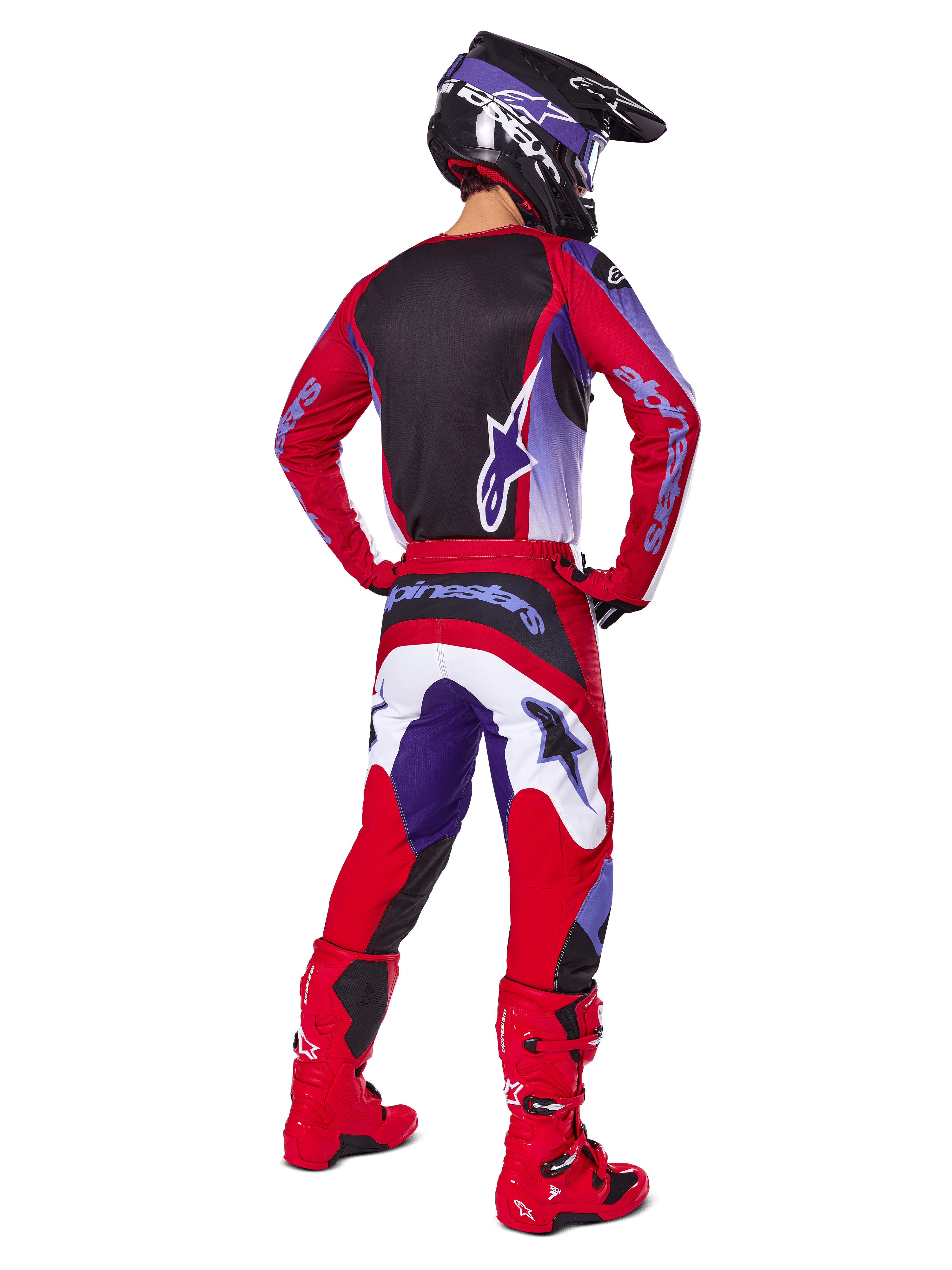 Motocross rider from behind wearing Alpinestars 2025 Fluid Wurx Pants, Purple Bright Red with white and black accents, matching jersey, black helmet, and red boots, coordinated outfit for off-road racing