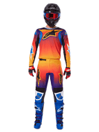 Alpinestars 2025 Fluid Wurx-byxor, motocrossbyxor, flerfärgad orange, gul och lila gradient, bärs med matchande tröja, svart hjälm med blå goggles, röda och svarta handskar och blå stövlar, koordinerad motocrossutrustning