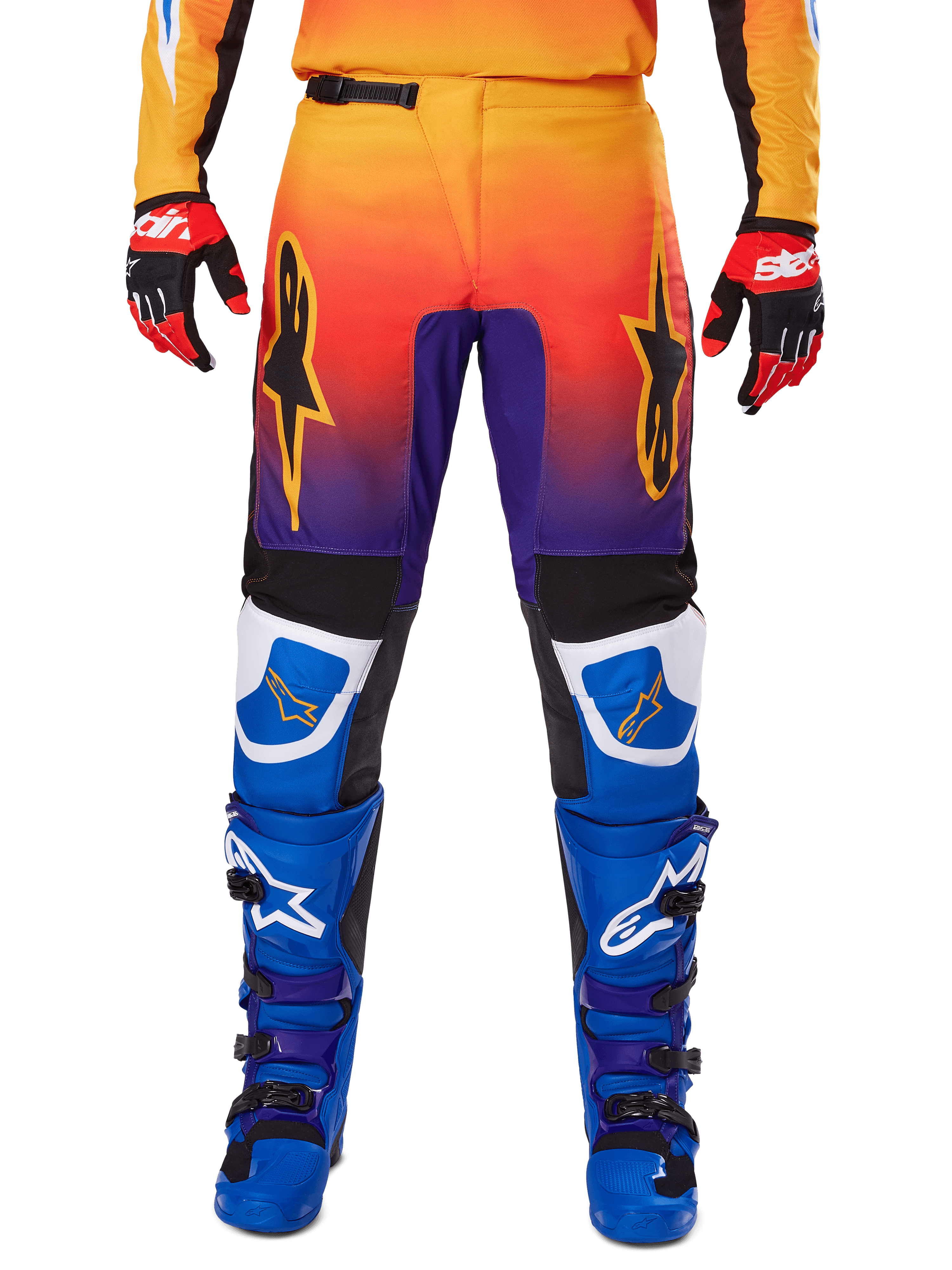 Alpinestars 2025 Fluid Wurx byxor, motocrossbyxor, flerfärgade med toning från orange till lila och blå paneler, bärs med matchande blå och lila stövlar samt röda och svarta handskar, vy framifrån med stjärnlogotyp