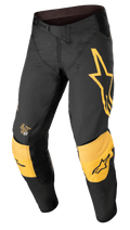 Alpinestars Techstar Quadro byxor, motocrossbyxor för terrängkörning, svarta och gula med tangerine-färgade detaljer, stor gul stjärnlogotyp på vänster lår, förstärkt gul knävaddering med svarta logotyper, ventilationshål och säker spärrstängning i midjan för en högpresterande racingpassform.