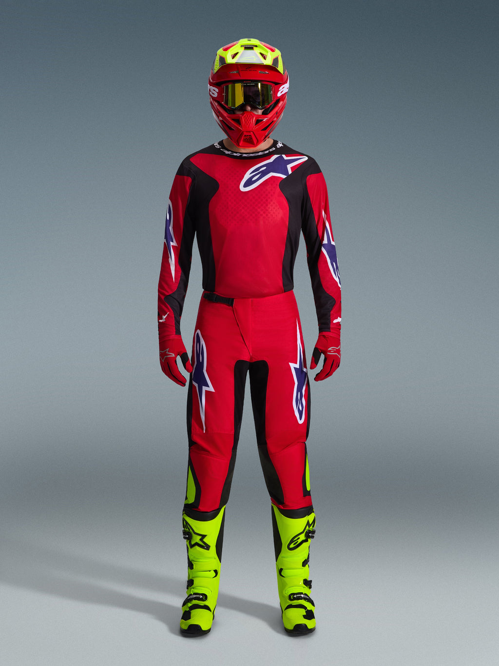 Alpinestars Fluid Grid Gear Set 2026, motocrossutrustning, röd och svart, komplett förarutrustning med röd tröja och byxor med blå och vita logotyper, matchande röd hjälm med neongula detaljer och neongula stövlar, högpresterande design för terrängkörning