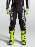 Alpinestars 2027 Fluid Apex V2 byxor, herrmotocrossbyxor i svart och silver med ergonomiska stretchpaneler, på modell.