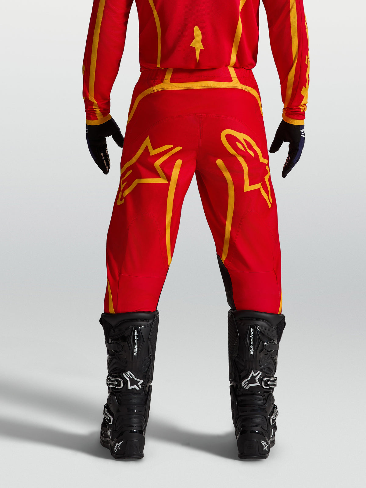 Alpinestars Fluid Apex V2 Pants, Men's Motocross Pants in Fire Red and Gold, Rear View with Black Boots.