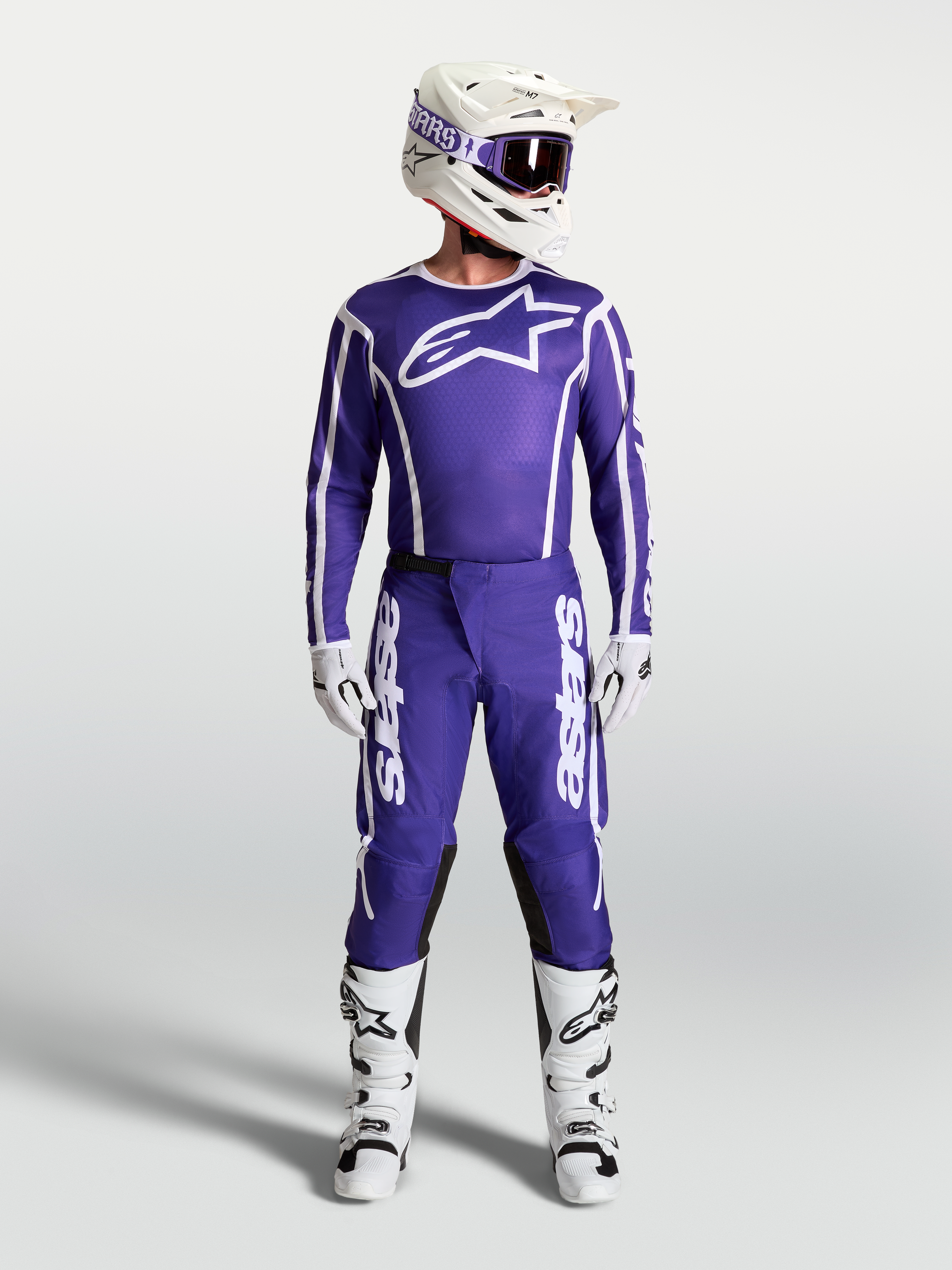 Alpinestars Fluid Apex V2-byxor, blå och vita herrmotocrossbyxor som visas med matchande racingtröja och stövlar.