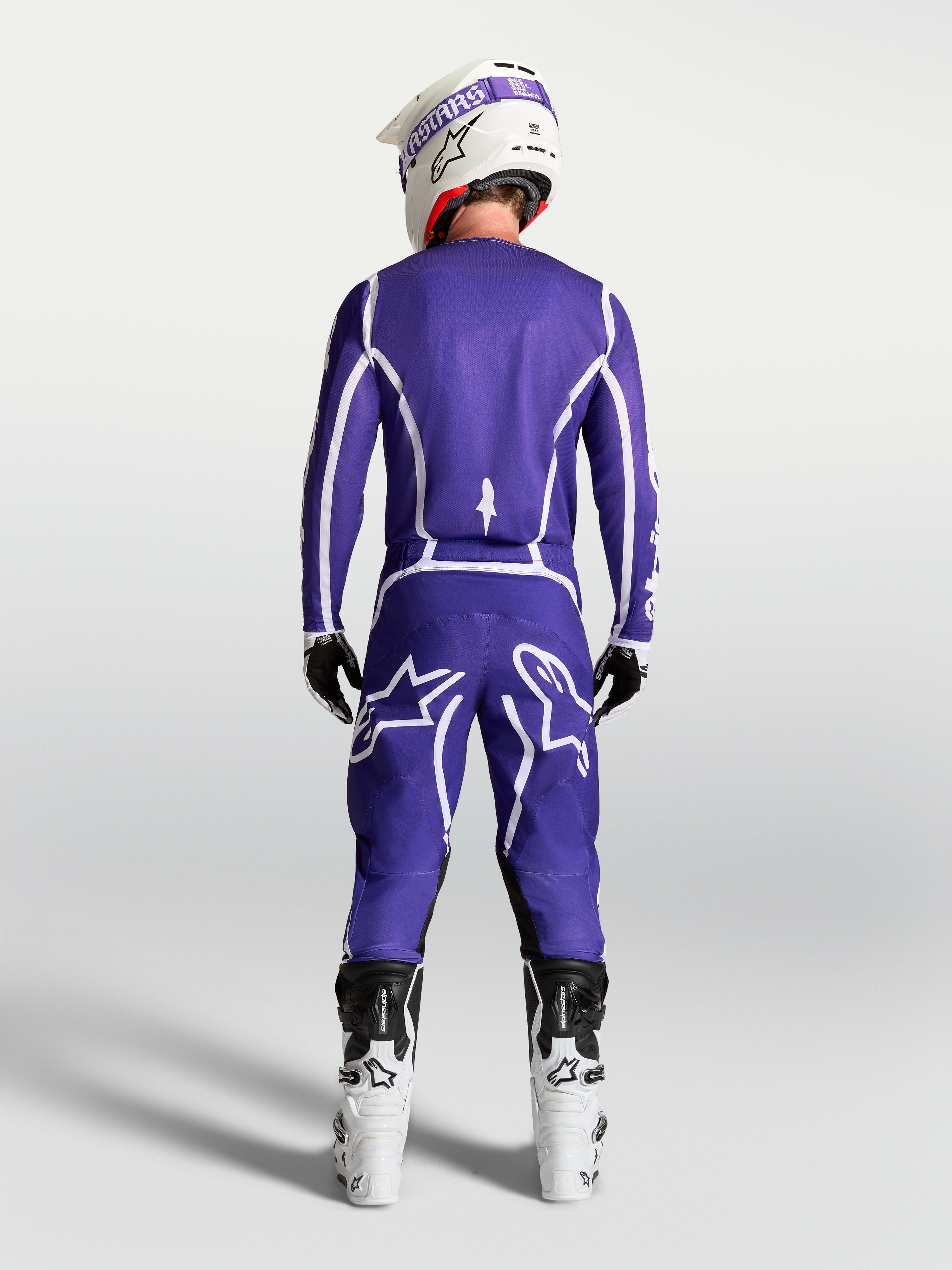 Alpinestars Fluid Apex V2 byxor, motocrossbyxor för herr, mörkblå och vita, vy bakifrån på modell med vita racingstövlar