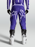 Alpinestars Fluid Apex V2 byxor, MX-byxor för herr, mörkblå och vita, hållbar 600D polytygskonstruktion med förböjda ben, vy bakifrån på modell med stövlar