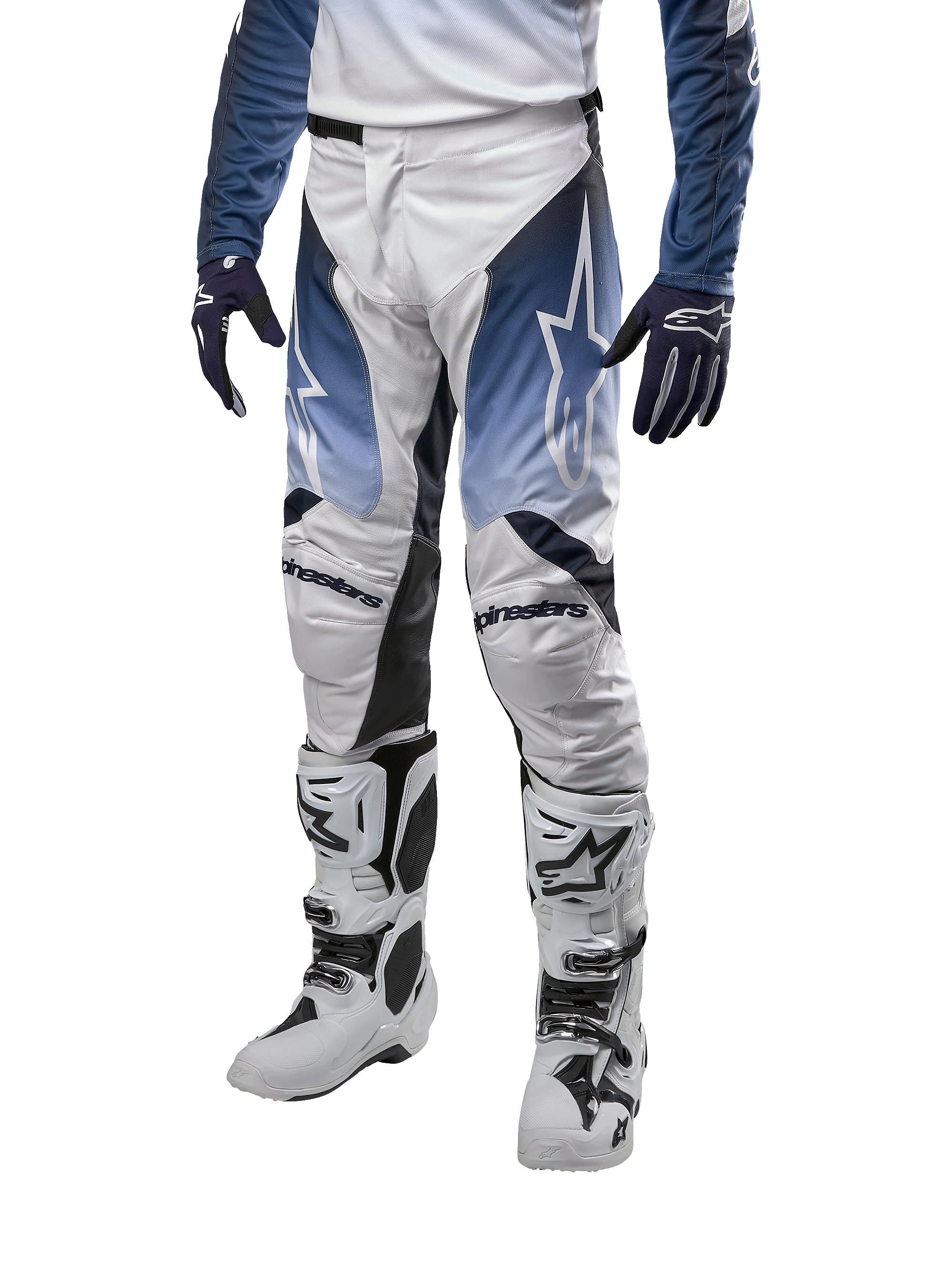 Alpinestars 2024 Racer Hoen byxor, motocrossbyxor i vitt, mörkblått och ljusblått, stjärnlogotyper på låren, Alpinestars-logotyp på knäna, visas med matchande tröja, handskar och vita motocross-stövlar, hållbart material för terrängkörning