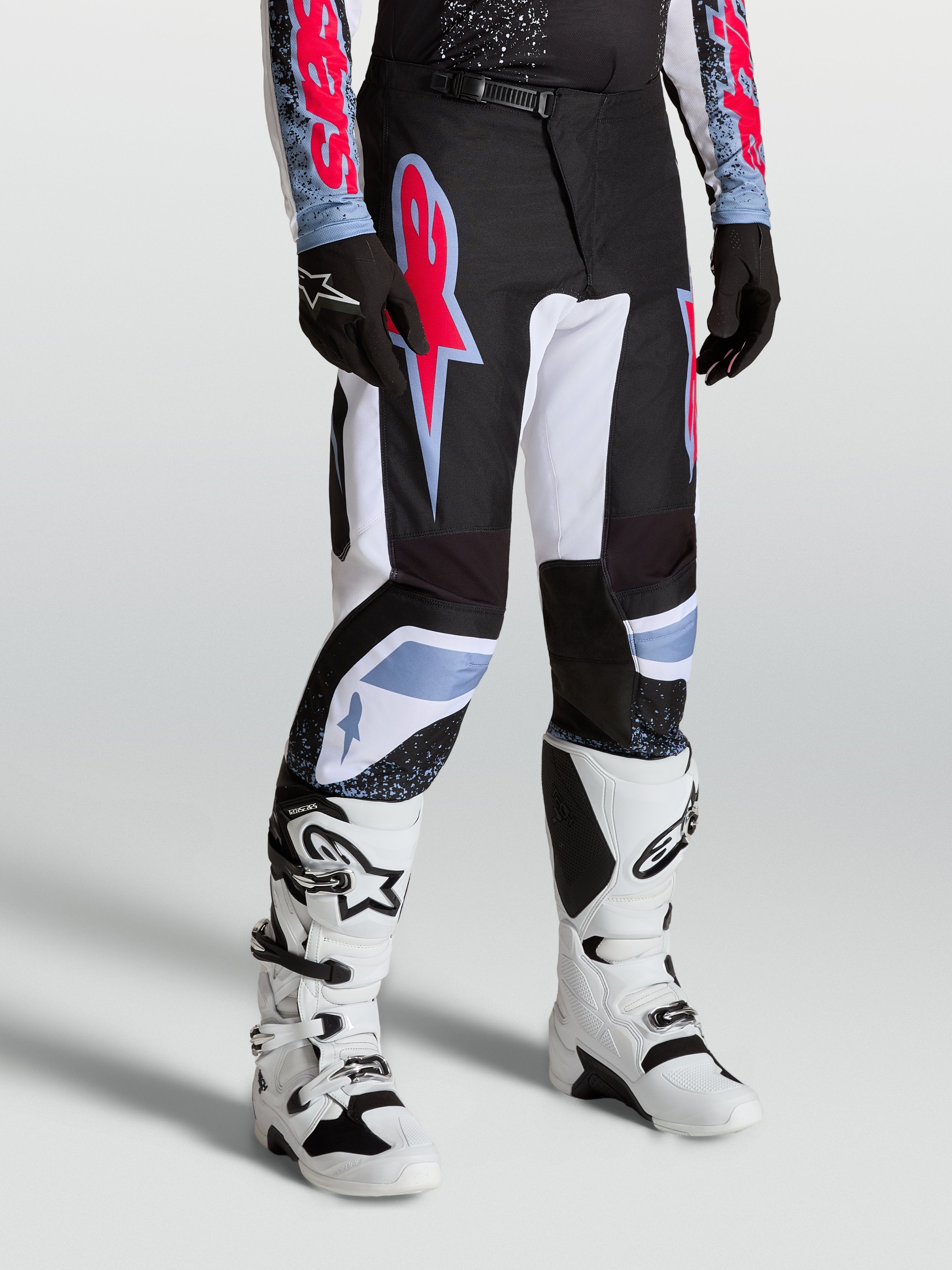 Alpinestars Fluid Drag byxor, herr-motocrossbyxor i svart och vitt med neonröda och ljusblå detaljer.