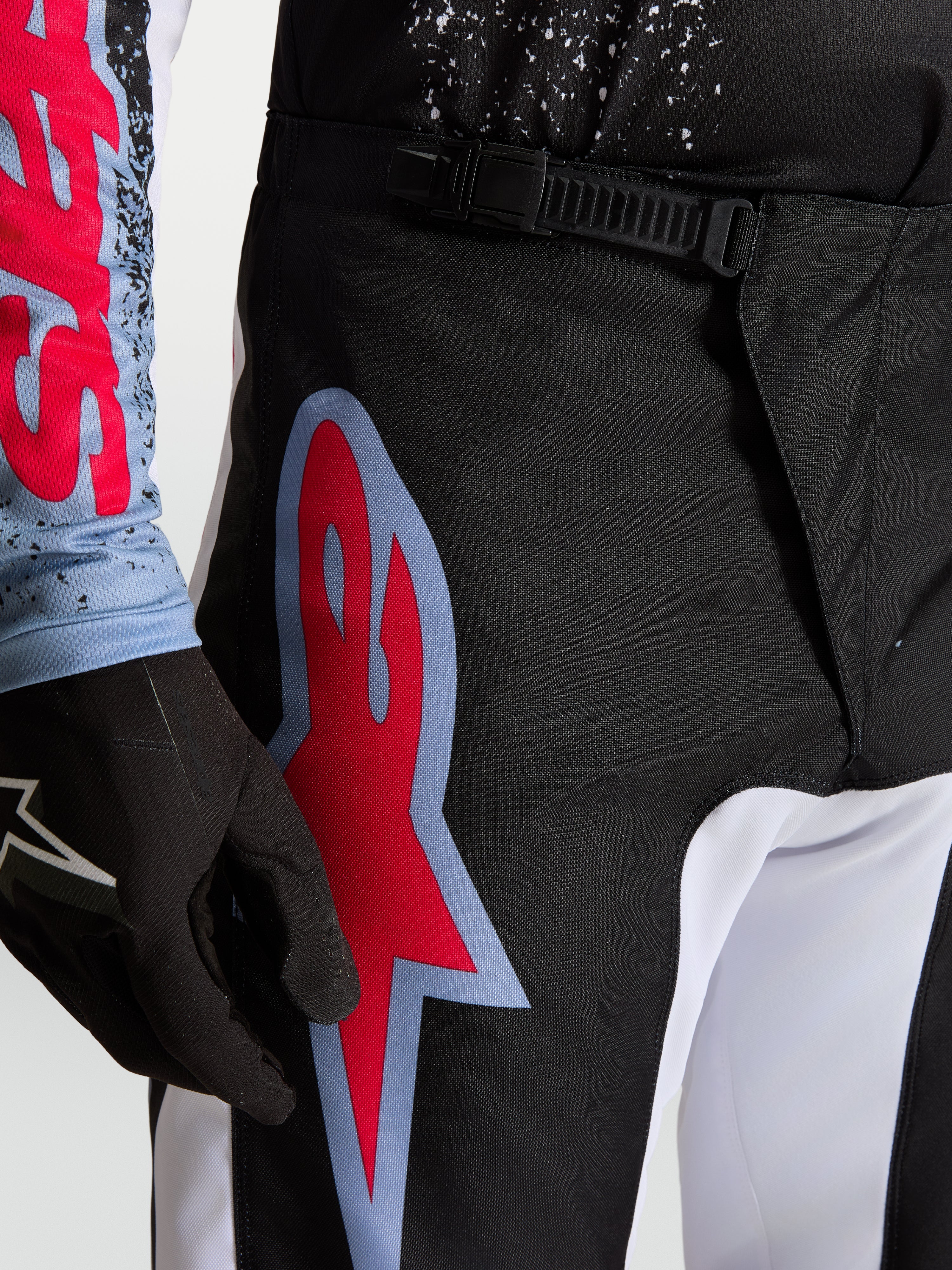 Alpinestars Fluid Drag byxor, motocrossbyxor för herrar, svarta och röda med midjeknäppning med spänne och stor grafisk Astars-logotyp.