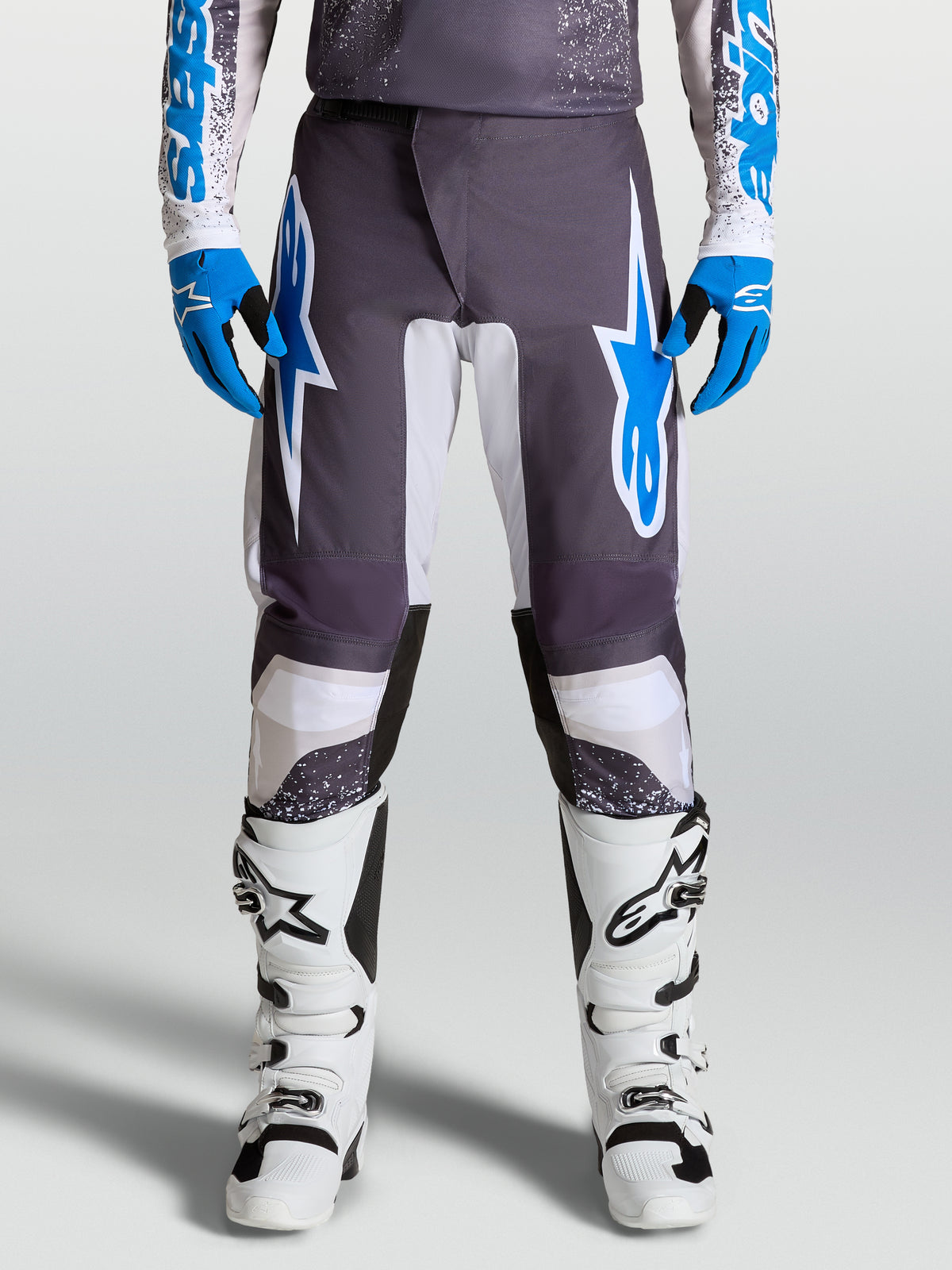 Alpinestars Fluid Drag Pants for motocross, Graystone and Ucla Blue, with pre-curved legs and ergonomic polyfabric protection.
