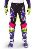 Alpinestars Limited Edition Supertech Dirt Studios byxor, motocrossbyxor, vit, lila och neongul, med svarta paneler samt neongula och rosa detaljer, stora lila stjärnlogotyper, visas med matchande neongula handskar och lila racingstövlar, hållbara kläder för terrängkörning