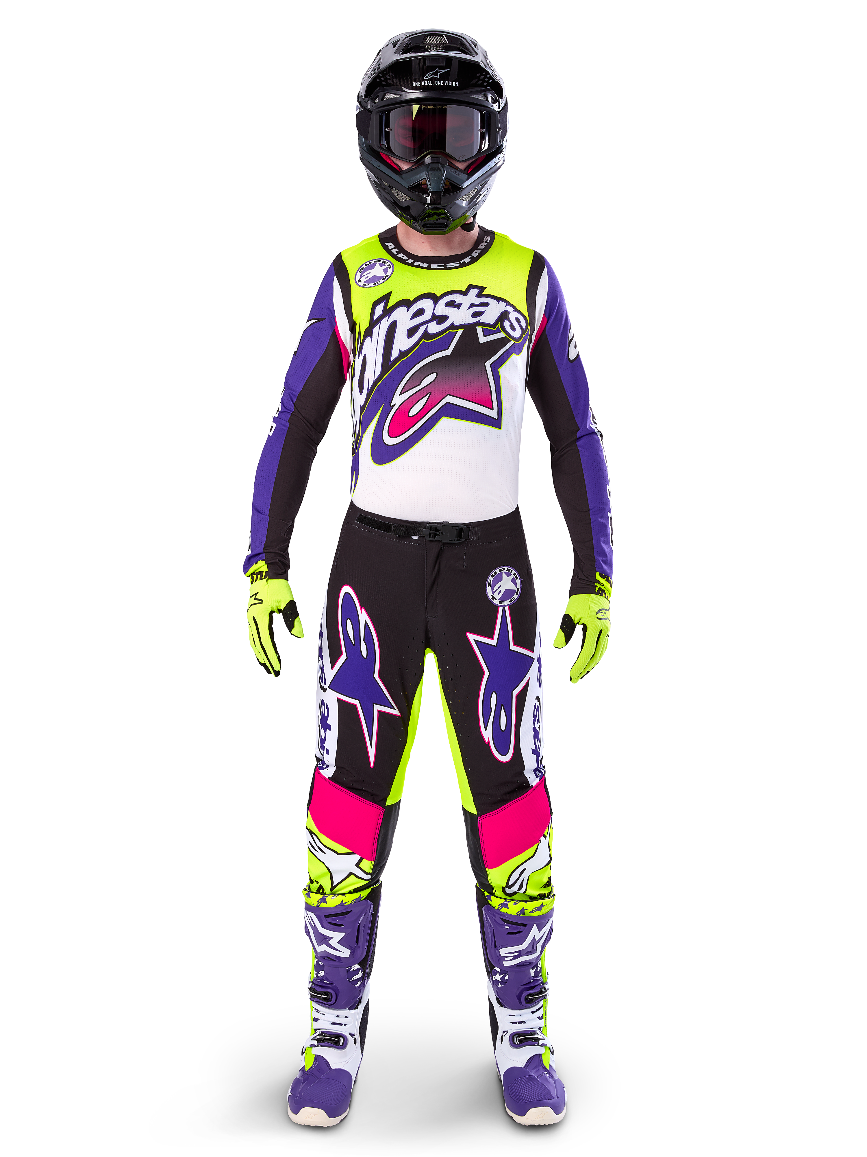 Motocrossförare i komplett racingutrustning, Limited Edition Supertech Dirt Studios-tröja och byxor i vitt, lila och gul fluo, svart hjälm med goggles, lila och vita stövlar, matchande färgstark outfit för motocross