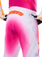 Alpinestars Limited Edition Supertech AFD MIG-byxor, motocrossbyxor, rosa fluo och vita med spraymålad fade-effekt, stor orange Alpinestars-logotyp på bakre linningen, närbild som visar atletisk passform och ventilationsperforeringar.