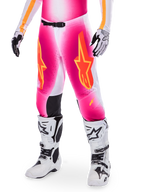 Alpinestars Supertech AFD MIG Limited Edition motocrossbyxor, rosa med orangea och gula stjärnlogotyper, bärs med vita motocross-stövlar och svartvita handskar, svarta innerpaneler vid knäna, atletisk passform, en del av ett högpresterande racingställ