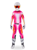 Motocrossförare iförd Alpinestars Limited Edition Supertech AFD MIG-utrustning, livfullt rosa fluo och vit tröja och byxor med tonad färgövergång och orange logotyper, vit hjälm med röda goggles, vita och svarta stövlar och handskar, koordinerad professionell racingoutfit