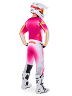 Motocrossförare sedd bakifrån bärande Limited Edition Supertech AFD MIG-utrustningsset, rosa tröja med orangea detaljer, vita byxor med rosa färgövergång och orange Alpinestars-branding, vit hjälm med rosa grafik och orangea goggles, vita och svarta stövlar, professionellt racingställ för terrängkörning