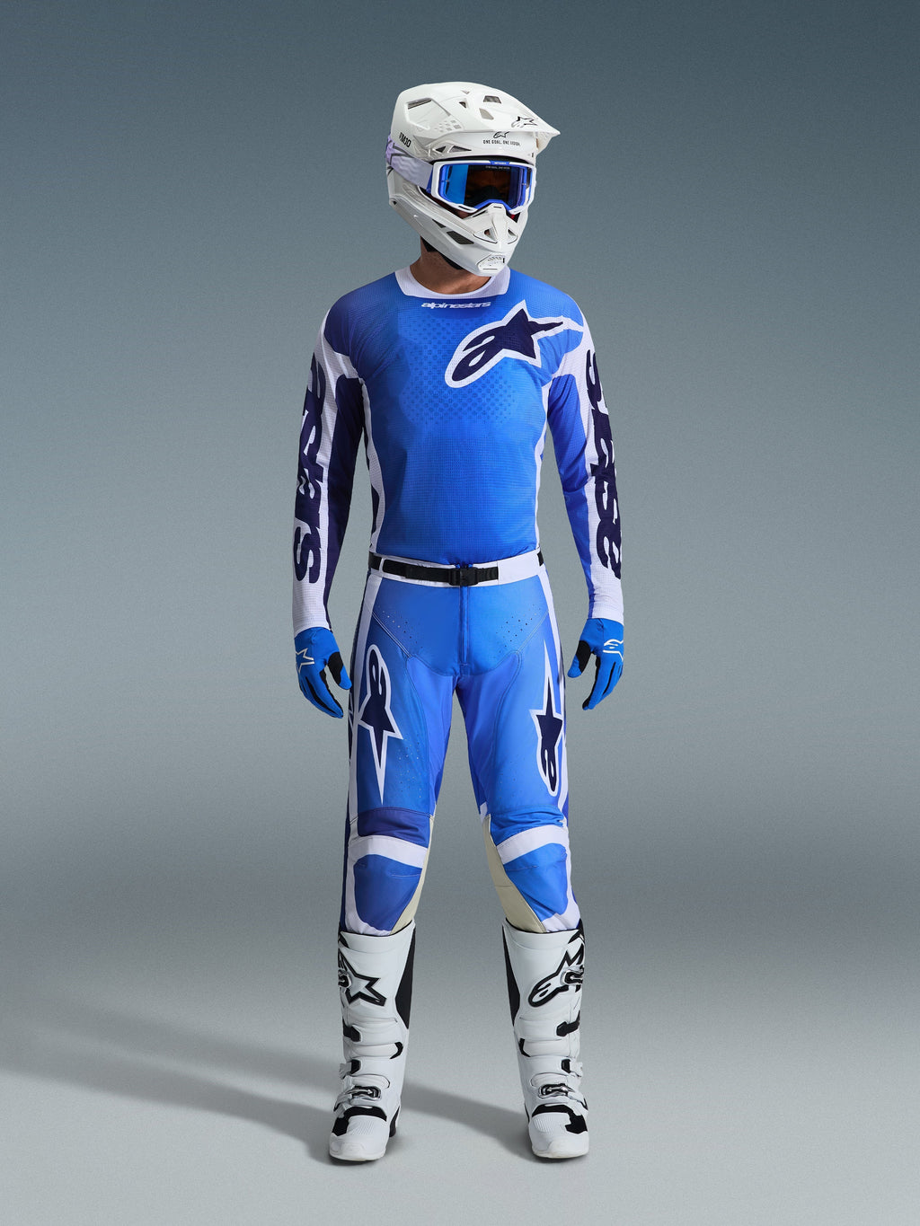Alpinestars 2026 Racer Air Portl Pants, Motocross Pants, Ucla Blue and White, worn as part of a complete racing gear set with a matching jersey, white helmet, blue goggles, and white boots, featuring high-airflow perforated panels and bold branding for off-road performance.