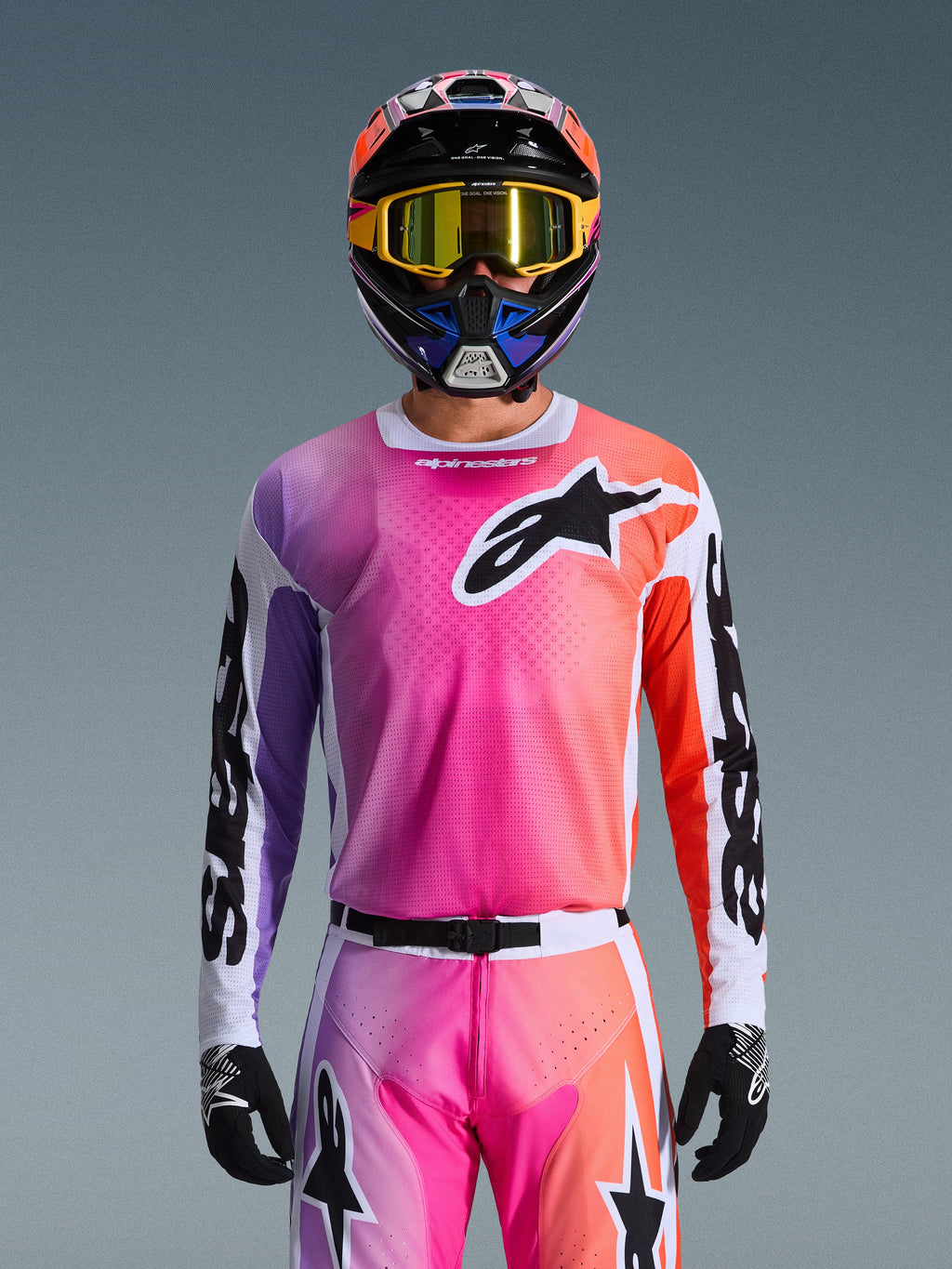 Alpinestars 2026 Racer Air Portl-tröja, motocrosströja, livfull toning i rosa, lila och orange, bärs med matchande hjälm och goggles, med en stor svart stjärnlogotyp på bröstet, ventilerande mesh-konstruktion, prestandautrustning för terrängkörning