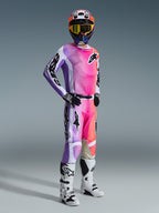 Motocrossförare i Alpinestars 2026 Racer Air Portl-tröja och matchande byxor, färgstark gradient i rosa, lila och orange med vita detaljer, matchande färgstark hjälm och gula goggles, vita och svarta stövlar, komplett racingoutfit för terrängprestanda