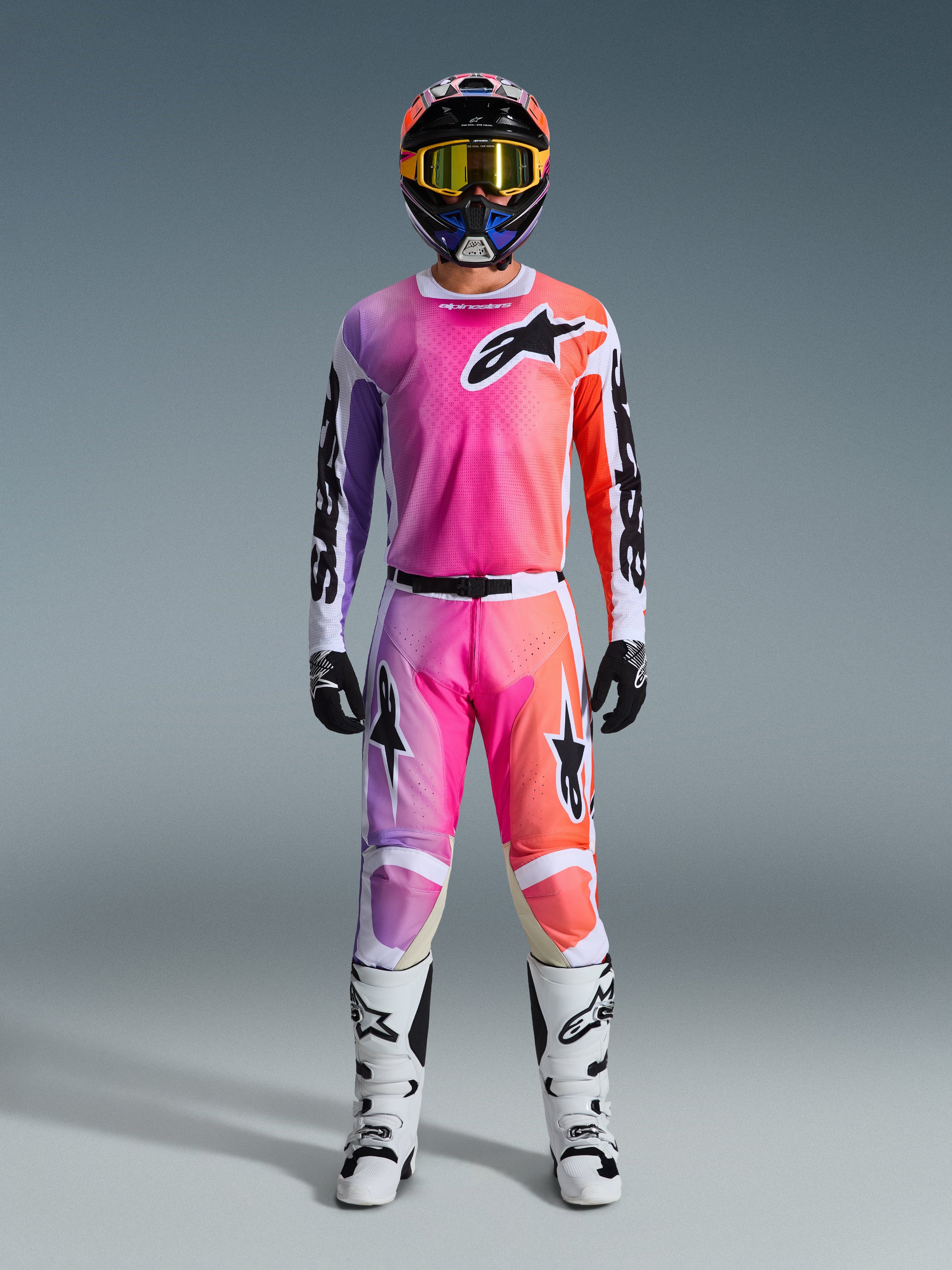 Alpinestars 2026 Racer Air Portl utrustningsset, motocross-utrustning, rosa, lila och orange, komplett outfit med matchande hjälm, gula goggles, svarta handskar och vita stövlar, med framträdande stjärnlogotyper på bröstet och benen.