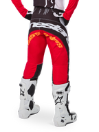 Alpinestars Limited Edition Techstar Deep Pants, Motocross Pants, Black White and High Red, rear view featuring bold white Alpinestars logo across the seat and orange branding, worn with white technical boots for professional off-road racing.