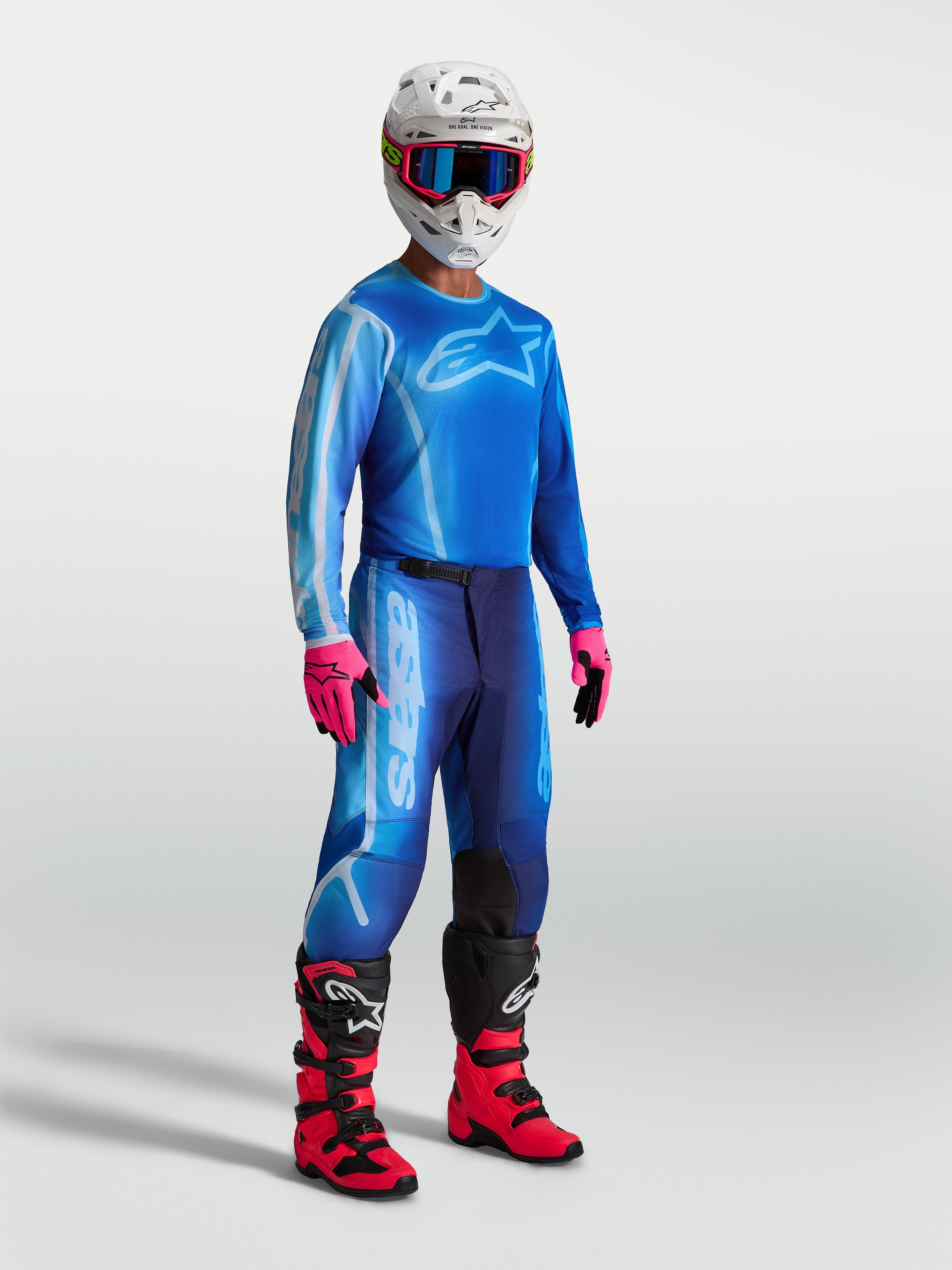 Alpinestars Fluid Kepler byxor, blå motocrossbyxor för herr, slitstark 600D polytygskonstruktion med förböjd bendesign, visas på modell med fullständig MX-utrustning.
