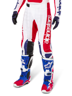 Alpinestars Limited Edition Techstar Fortitude Motocross Pants, Red White and Blue color scheme, worn with matching motocross boots and gloves, featuring vertical Alpinestars branding, athletic fit design for off-road racing