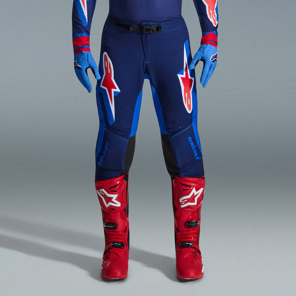 Alpinestars 2026 Supertech Vista Gear Set, motocrossbyxor i marinblått och klarblått med röda och vita logotyper, kombinerade med ljusblå handskar och klarröda motocross-stövlar, professionell racingutrustning.
