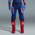 Alpinestars 2026 Supertech Vista Gear Set, motocrossbyxor i marinblått och klarblått med röda och vita logotyper, kombinerade med ljusblå handskar och klarröda motocross-stövlar, professionell racingutrustning.