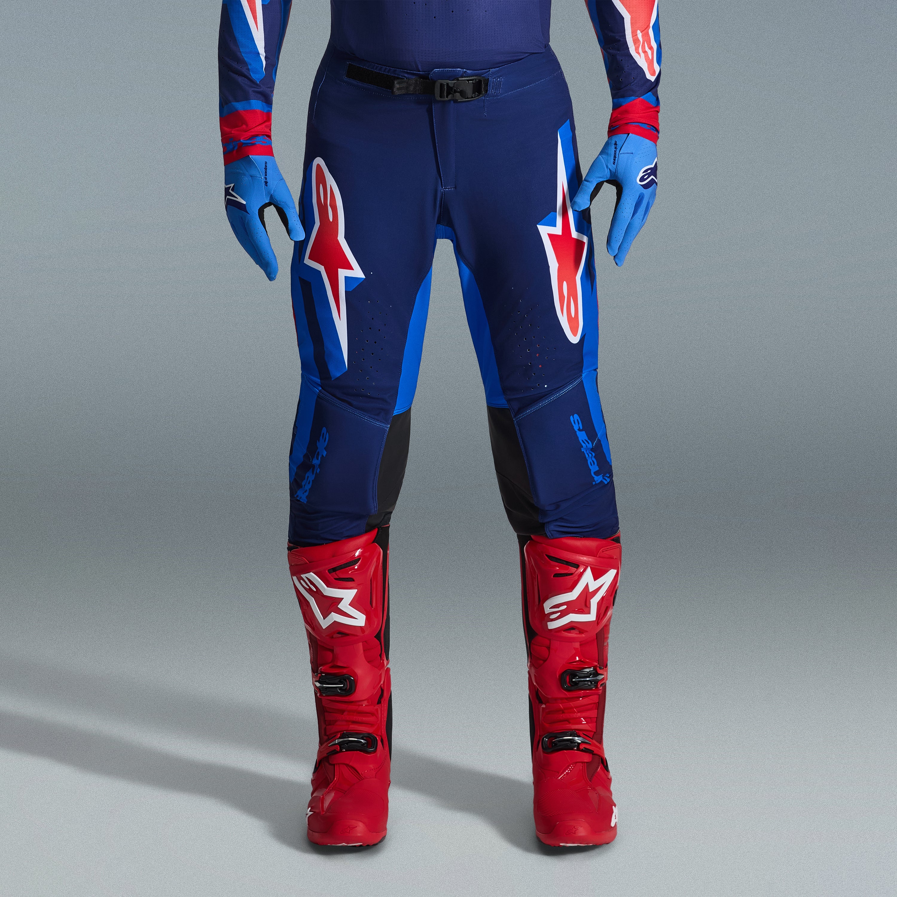 Alpinestars 2026 Supertech Vista Gear Set, motocrossbyxor i marinblått och klarblått med röda och vita logotyper, kombinerade med ljusblå handskar och klarröda motocross-stövlar, professionell racingutrustning.