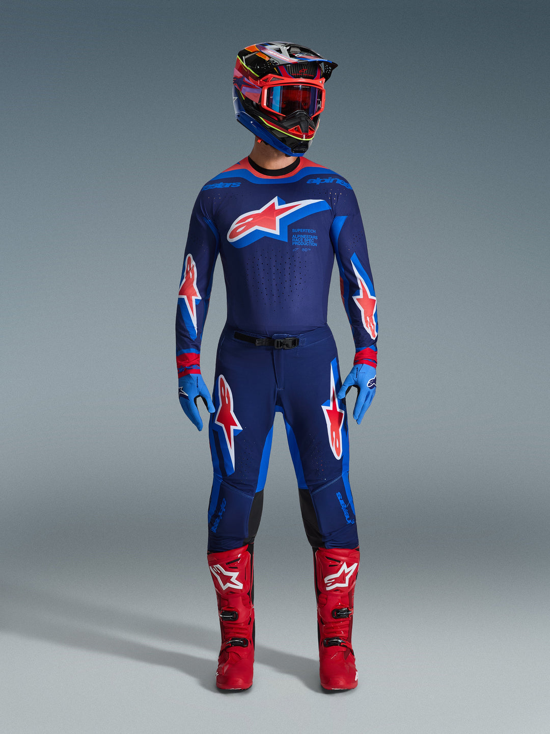 Alpinestars 2026 Supertech Vista Gear Set, komplett motocross-racingoutfit, mörkblå tröja och byxor med röda och vita stjärnlogotyper, flerfärgad hjälm med röda goggles, ljusblå handskar och klarröda stövlar, professionell MX-utrustning