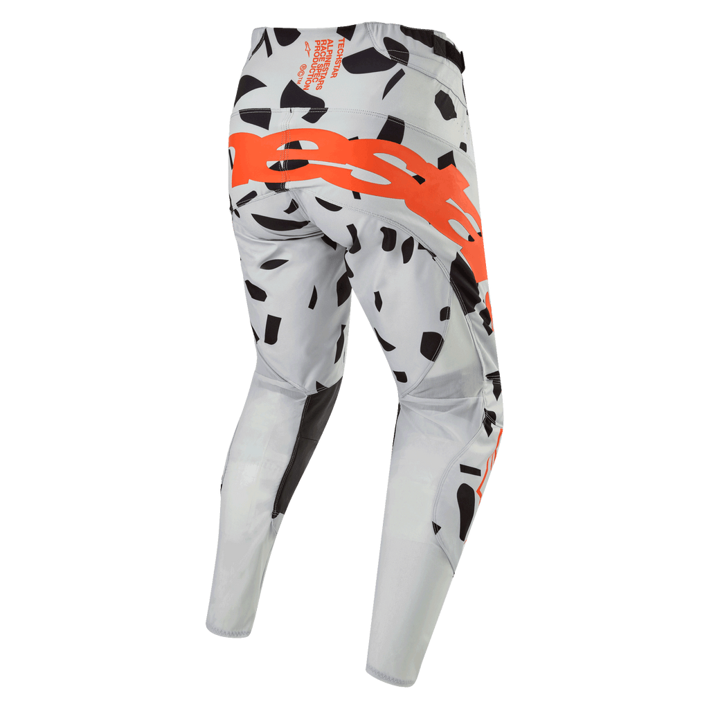 Alpinestars 2024 Techstar Rantera byxor, motocrossbyxor, Haze Gray Camo, vy bakifrån som visar en stor orange logotyp över sätet, svarta grafiska mönster på grått tyg, atletisk design för terrängkörning