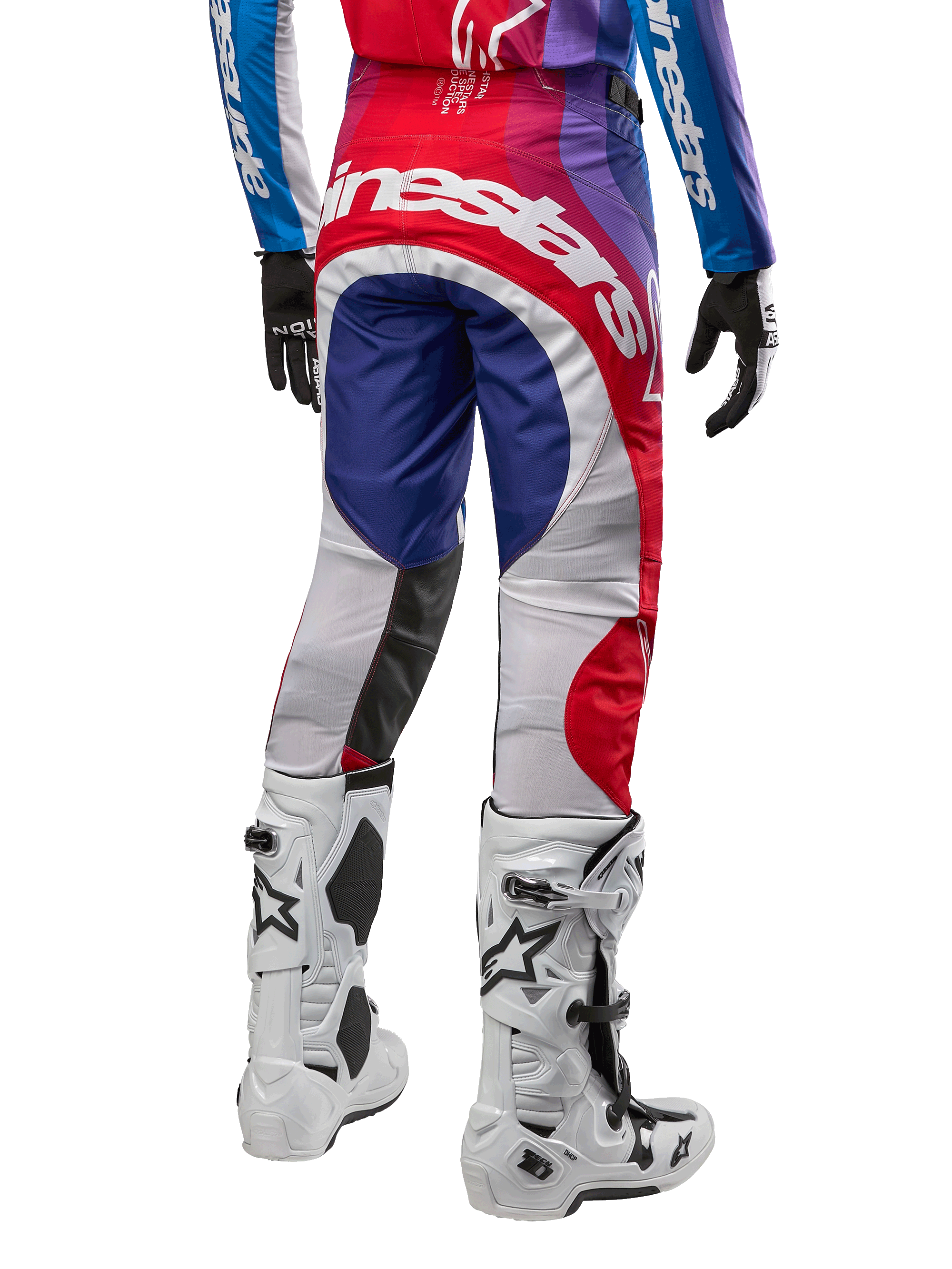 Alpinestars 2024 Techstar Pneuma byxor, motocrossbyxor, Blu Mars Red White, vy bakifrån bärs med matchande tröja och vita stövlar, med framträdande vit logotyp på sätet och flerfärgad paneldesign, professionell racingutrustning för motocross