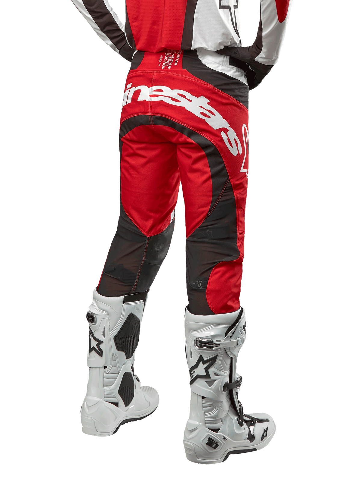 Alpinestars 2024 Techstar Ocuri byxor, motocrossbyxor, Mars Red, vit och svart, vy bakifrån med en stor vit Alpinestars-logotyp på sätet, svarta ventilationspaneler i mesh, bärs med vita och svarta motocross-stövlar, atletisk race-fit-design för terrängkörning