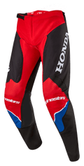 Alpinestars Honda Racer Iconic-byxor, motocrossbyxor, klarröda, svarta och vita med blå detaljer, stor vit HONDA-logotyp på låret, Alpinestars-logotyper på knäna, ergonomisk förböjd benkonstruktion och justerbart spännlås i midjan