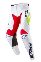 Alpinestars 2024 Racer Hana byxor, motocrossbyxor, vit multifärg med röda och svarta paneler på insidan av knäna, blå Astars-logotyper och neongul logotyp, förböjd design med midjestängning med spärrmekanism, slitstarkt textilmaterial för terrängkörning