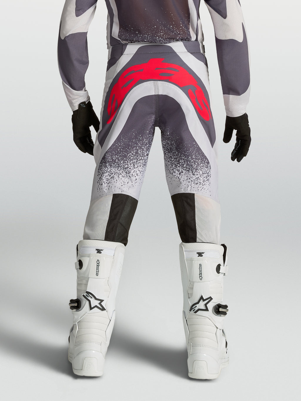Alpinestars Supertech Swan motocrossbyxor för ungdom, grå och röd fluo, vy bakifrån med atletisk passform och förstärkt säte.