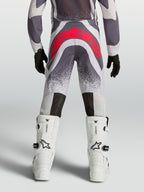 Alpinestars Supertech Swan motocrossbyxor för ungdom, grå och röd fluo, vy bakifrån med atletisk passform och förstärkt säte.