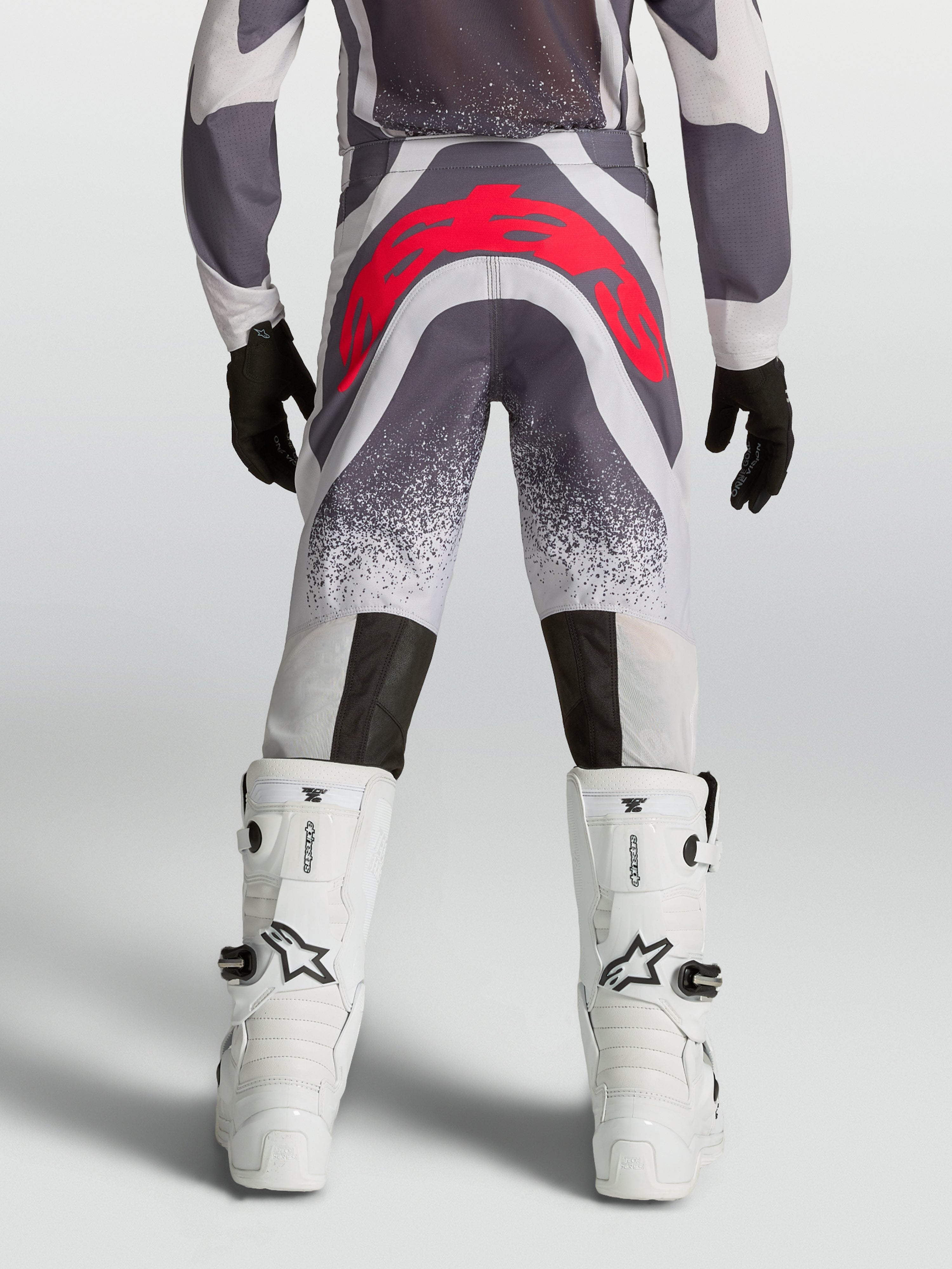 Alpinestars Supertech Swan motocrossbyxor för ungdom, grå och röd fluo, vy bakifrån med atletisk passform och förstärkt säte.