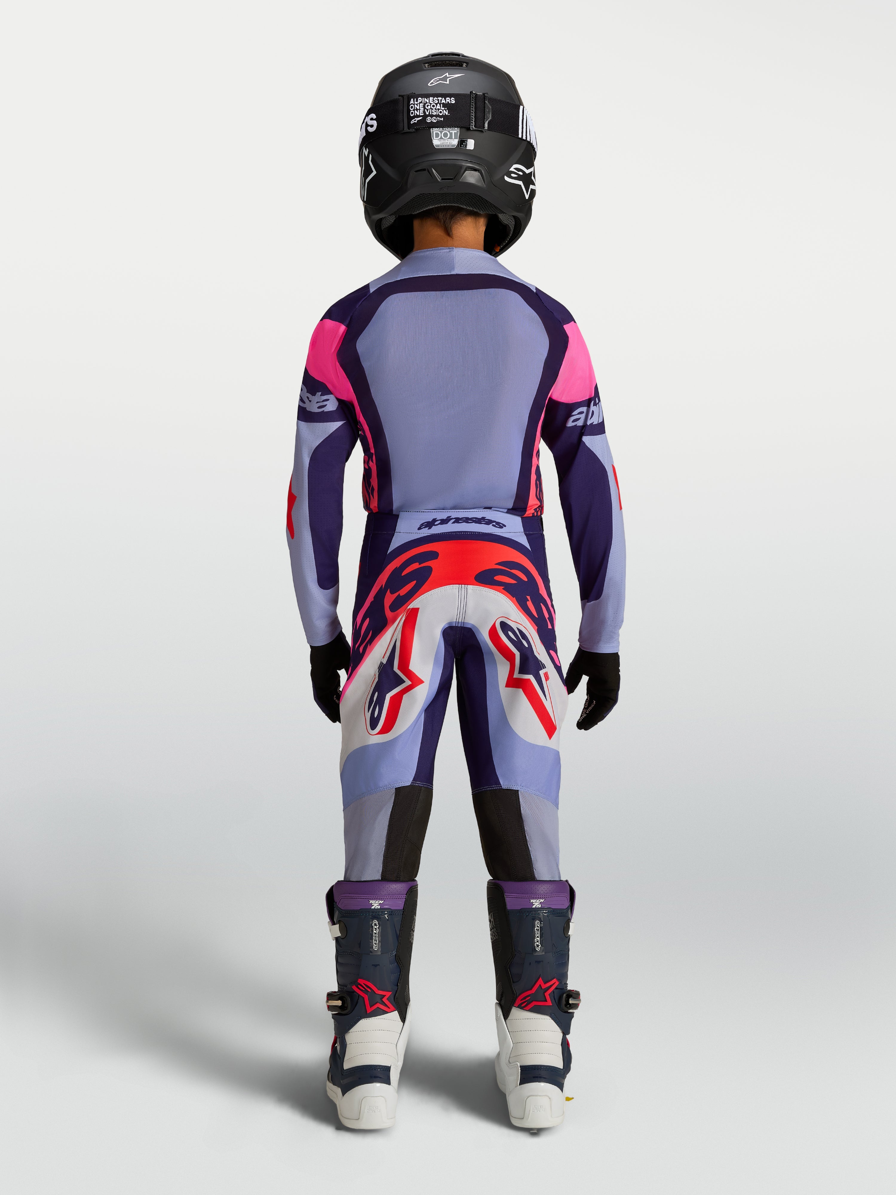 Alpinestars 2027 Supertech Dyna ungdomsbyxor, lila och ljusvioletta motocrossbyxor för racing, atletisk passform, vy bakifrån på förare i full utrustning.