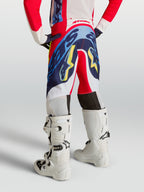 Alpinestars 2027 Supertech Dyna ungdomsbyxor, röda och marinblå motocrossbyxor, sedda bakifrån på en ung förare.