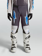 Alpinestars Ungdom Fluid Drag byxor, grå och blå motocrossbyxor i 600D polytyg med förstärkta knän.