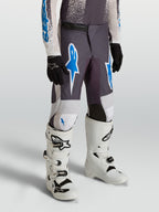 Alpinestars 2027 Ungdom Fluid Drag byxor, gråa och blåa motocrossbyxor i hållbart 600D-polytyg för terrängkörning.