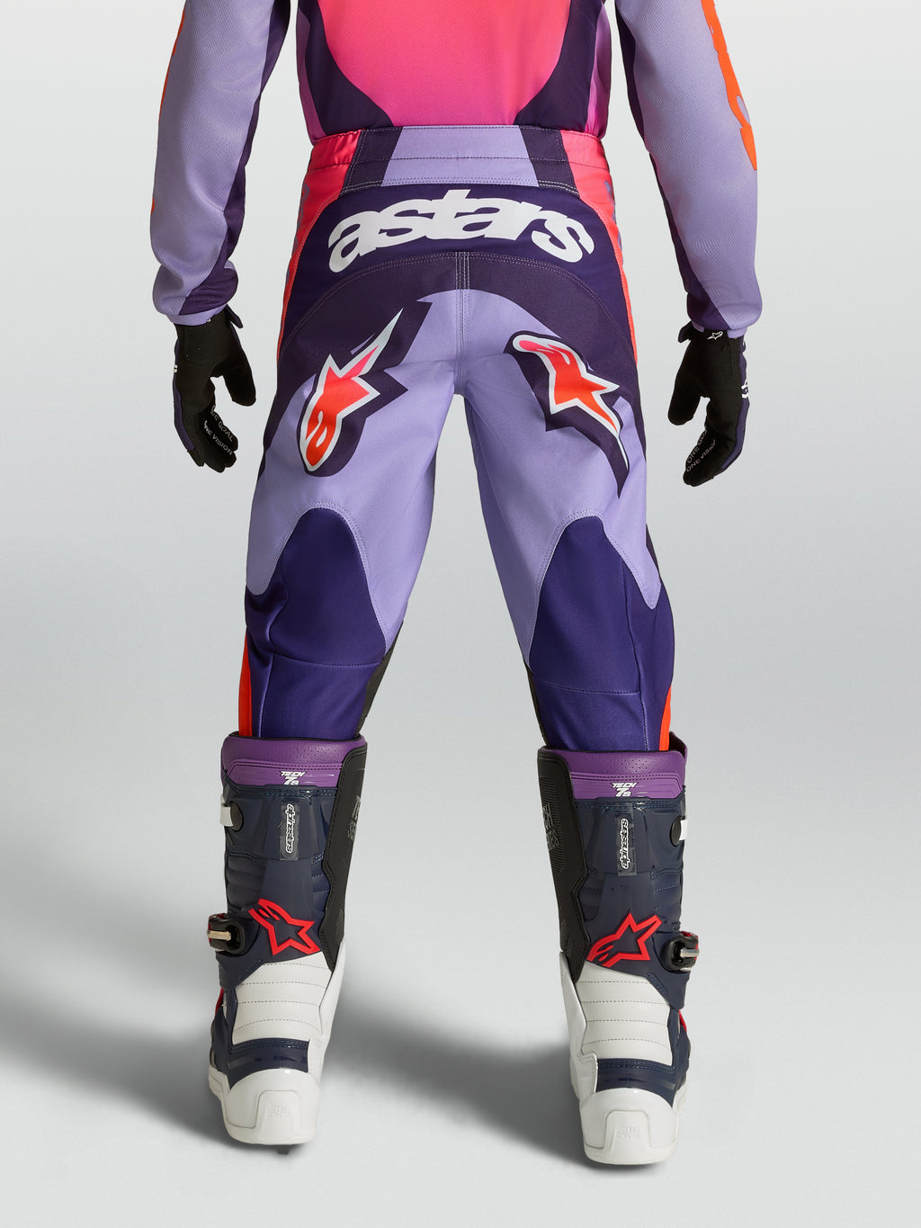 Alpinestars ungdom Fluid Hunt byxor, lila och rosa motocrossbyxor med stjärnlogotyper och hållbar textilkonstruktion.