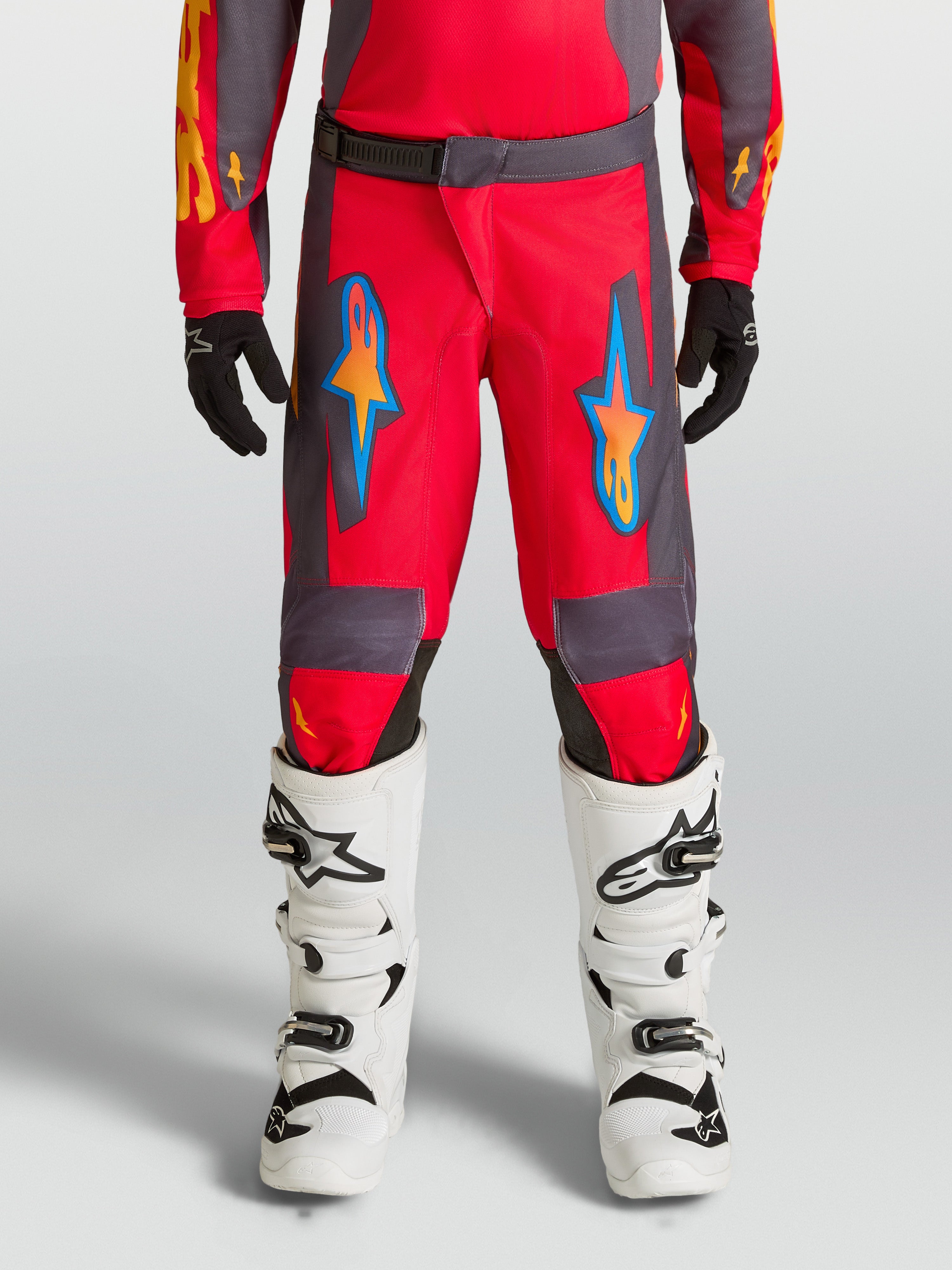 Alpinestars Youth Fluid Hunt byxor, röda och gråa motocrossbyxor för ungdomar, terrängkörning, ergonomisk design i polytyg.