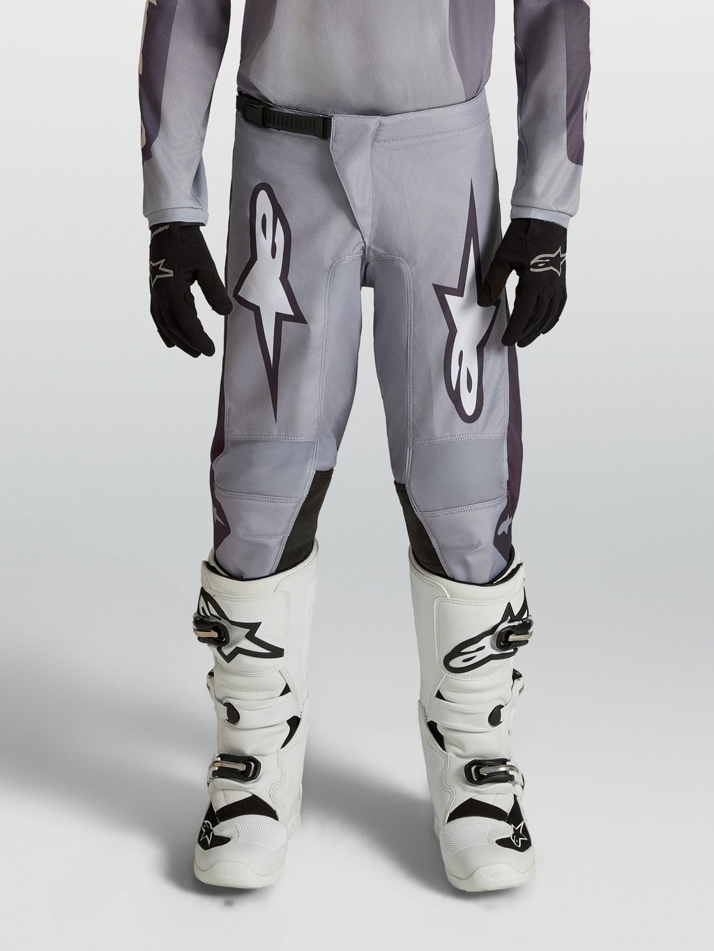 Alpinestars 2027 Fluid Amber ungdomsbyxor, gråa och svarta motocrossbyxor, slitstarkt 600D-polytyg, ergonomisk design för unga förare vid terrängkörning.